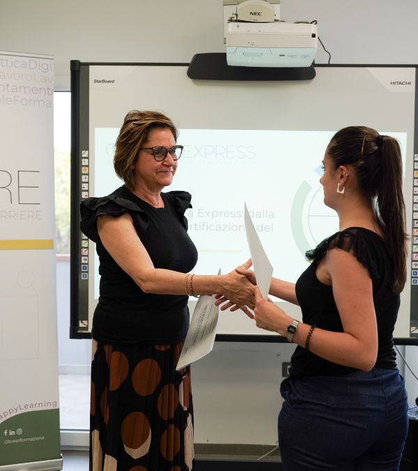 nella foto vediamo una donna che riceve un attestato. la foto è stata scattata durante un'edizione del corso per diventare orientatore certificato orienta express