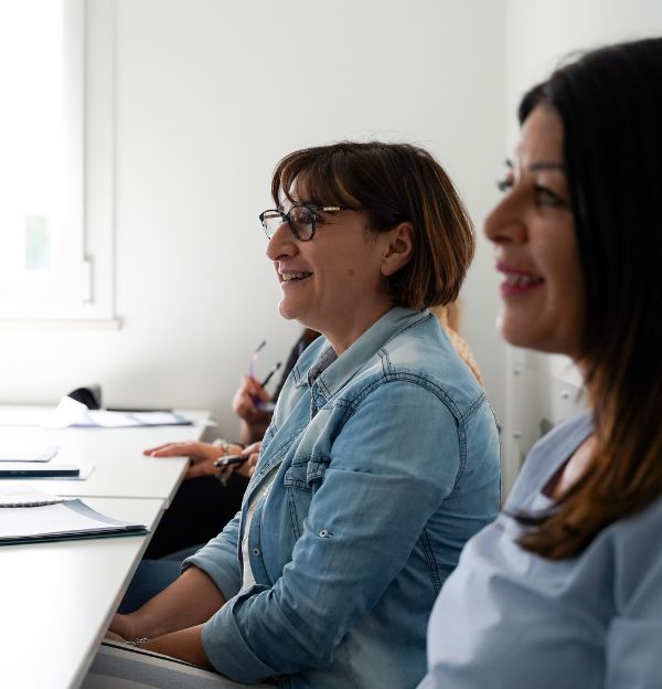 nella foto vediamo 2 donne che sorridono. la foto è stata scattata durante un'edizione del corso per diventare orientatore certificato orienta express