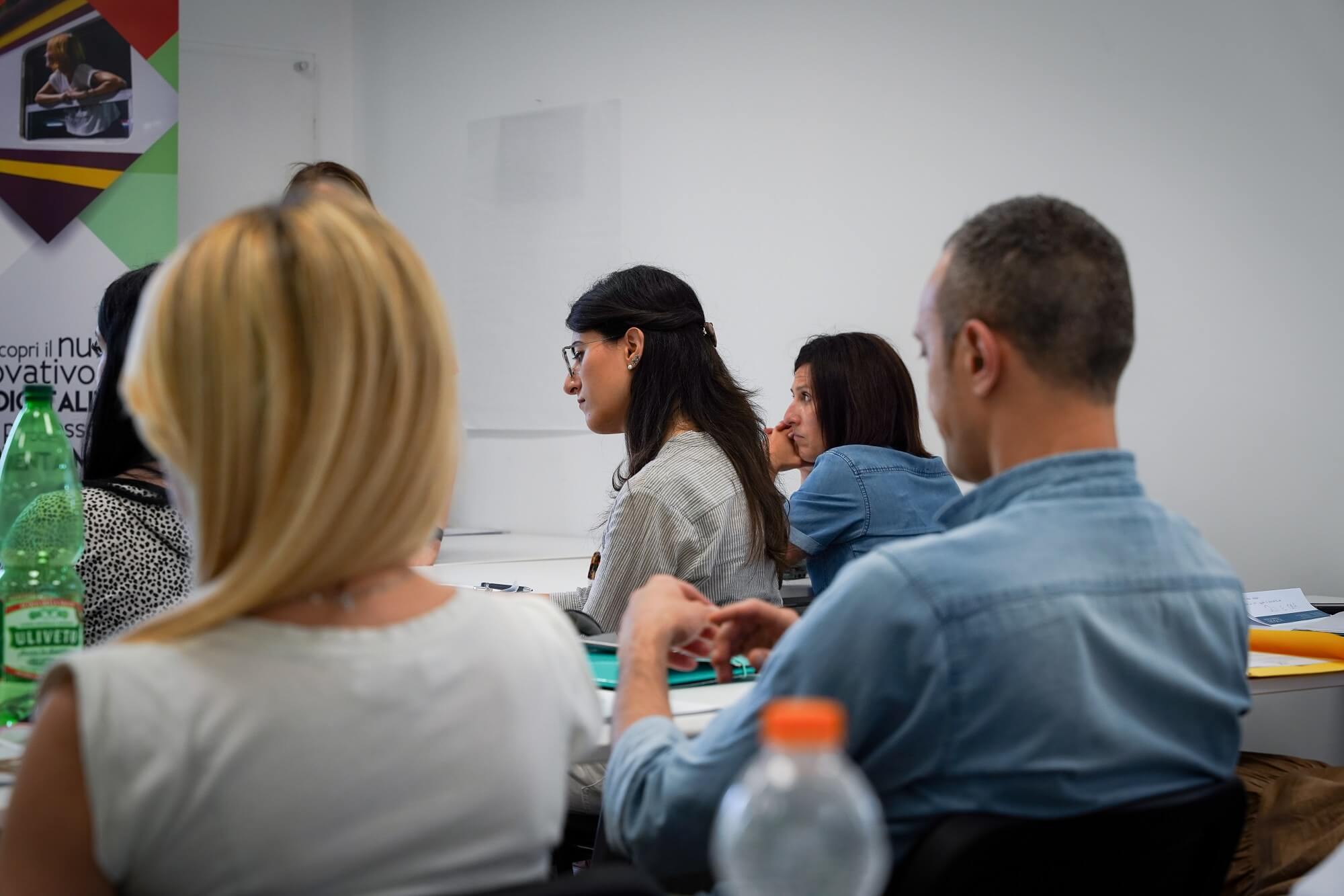 Nella foto vediamo un gruppo di persone che ascolta una lezione. la foto è stata scattata durante un'edizione del corso per diventare orientatore certificato orienta express